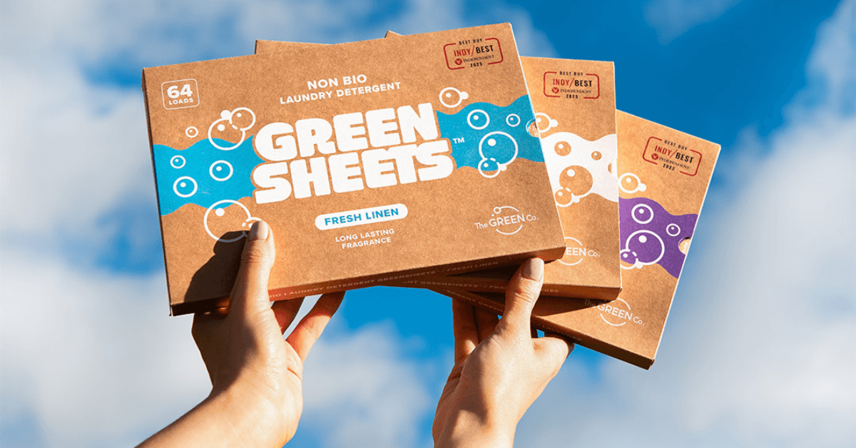 laundry detergent greensheets packs held against blue sky