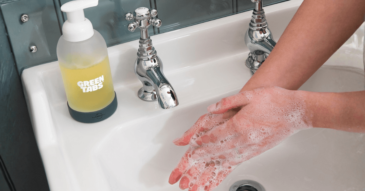 washing hands with foaming eco friendly hand wash at bathroom sink