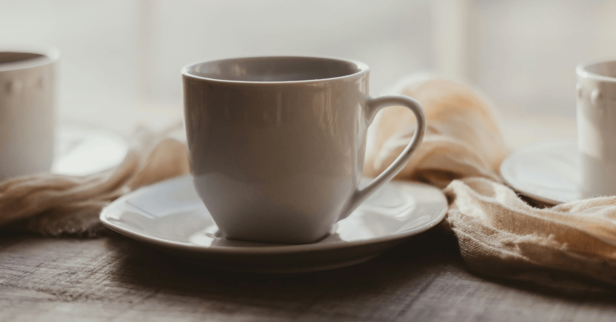 white tea cup and saucer sitting on table