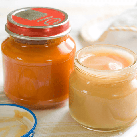 orange baby food in glass tins
