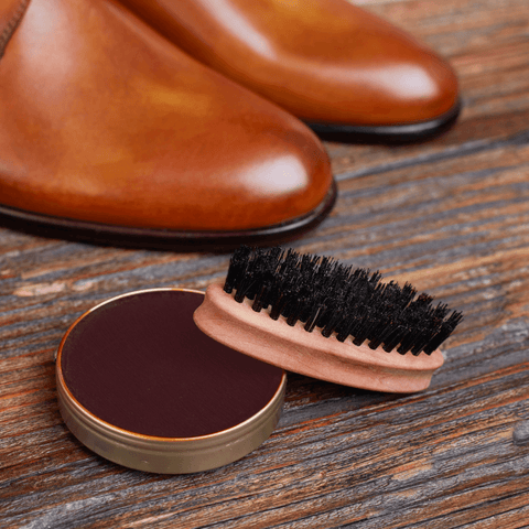 brown shoe polish with brush beside brown leather shoe pair