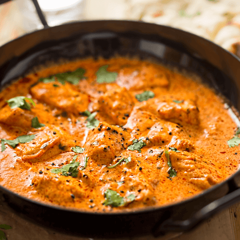cooked orange curry in big iron pan
