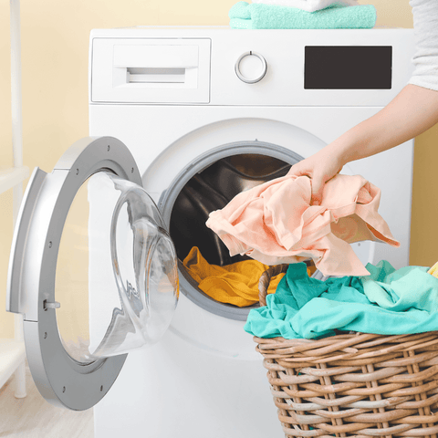 laundry basket emptied into washing machine with laundry detergent sheets GreenSheets