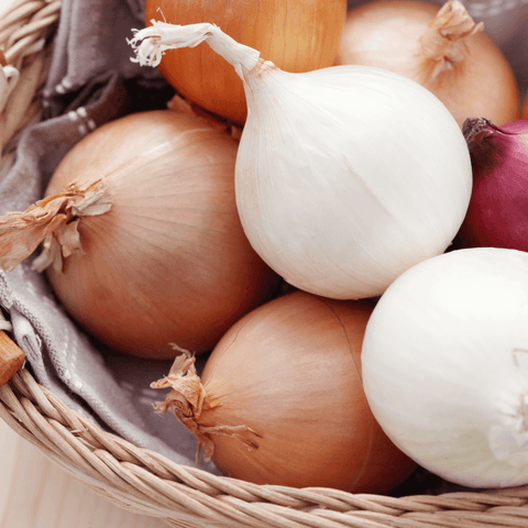 multi coloured onions in woven basket