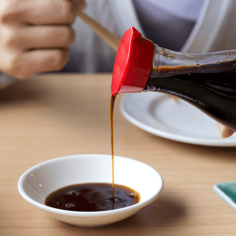 soy sauce poured into ceramic dish bowl
