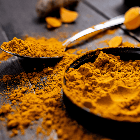 yellow turmeric powder on metal spoon