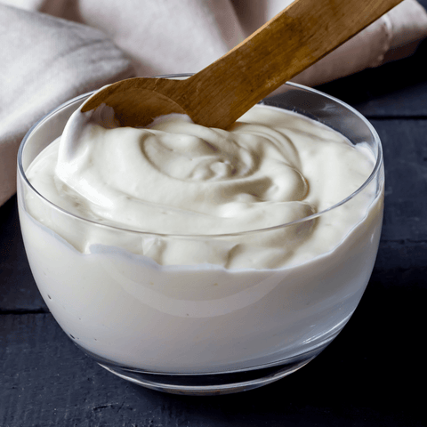 yoghurt in glass bowl with wooden spoon